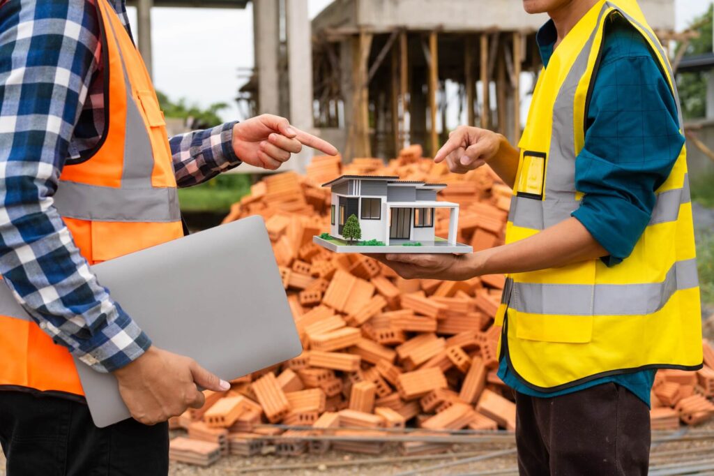 A Male Architect In A Hard Hat Safety Vest Reviews Construction Documents Construction Contractor - Inlet Mechanical