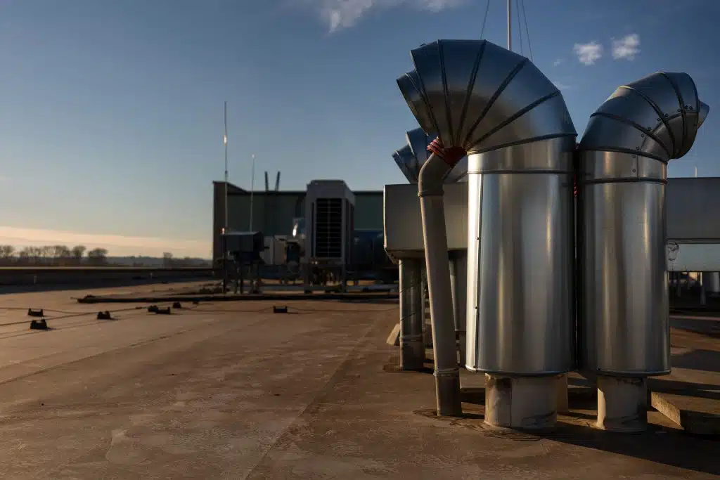 External unit of commercial air conditioning and ventilation system installed on industrial building roof. Exhaust vent on flat factory rooftop
