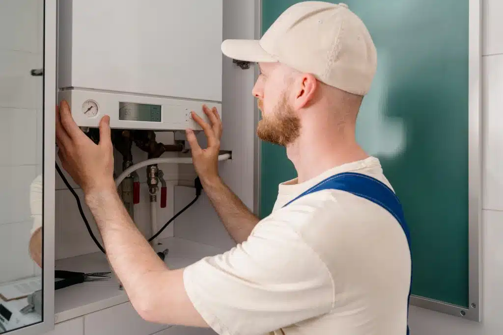 Technician checking water heating equipment controls for efficiency
