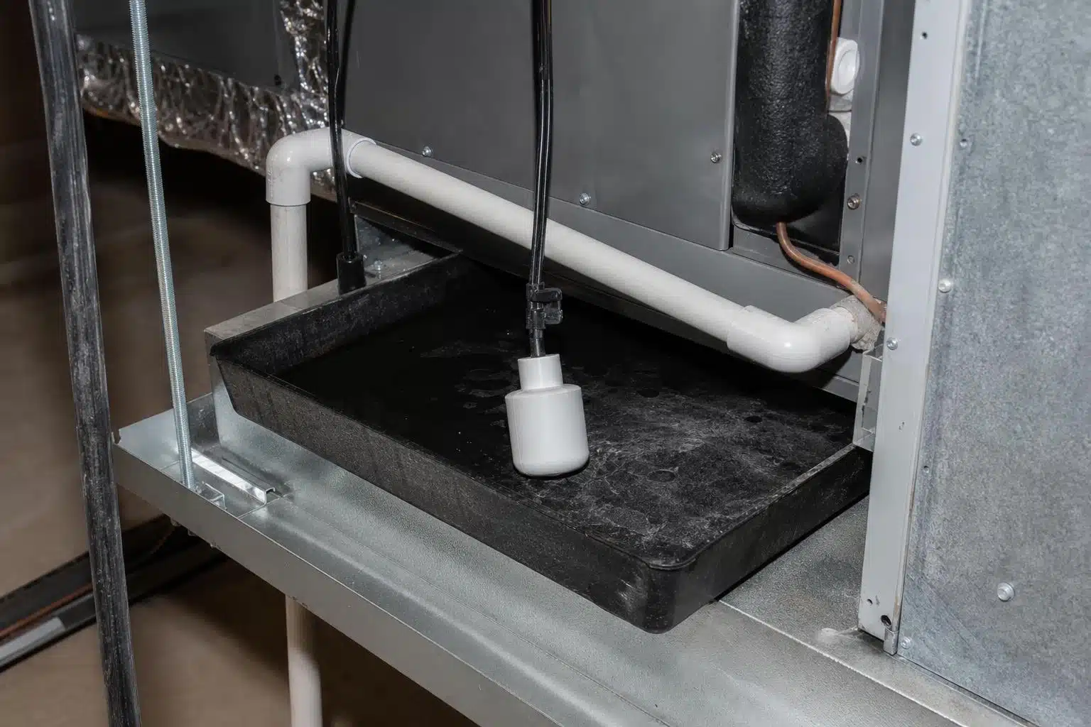 Float switch in air handler secondary drain pan indicating water backup