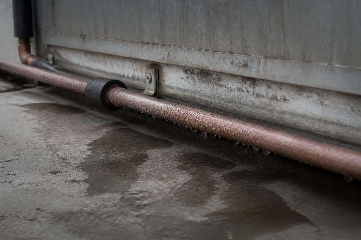 Condensation beading on a bare copper suction line where the insulation has fallen away