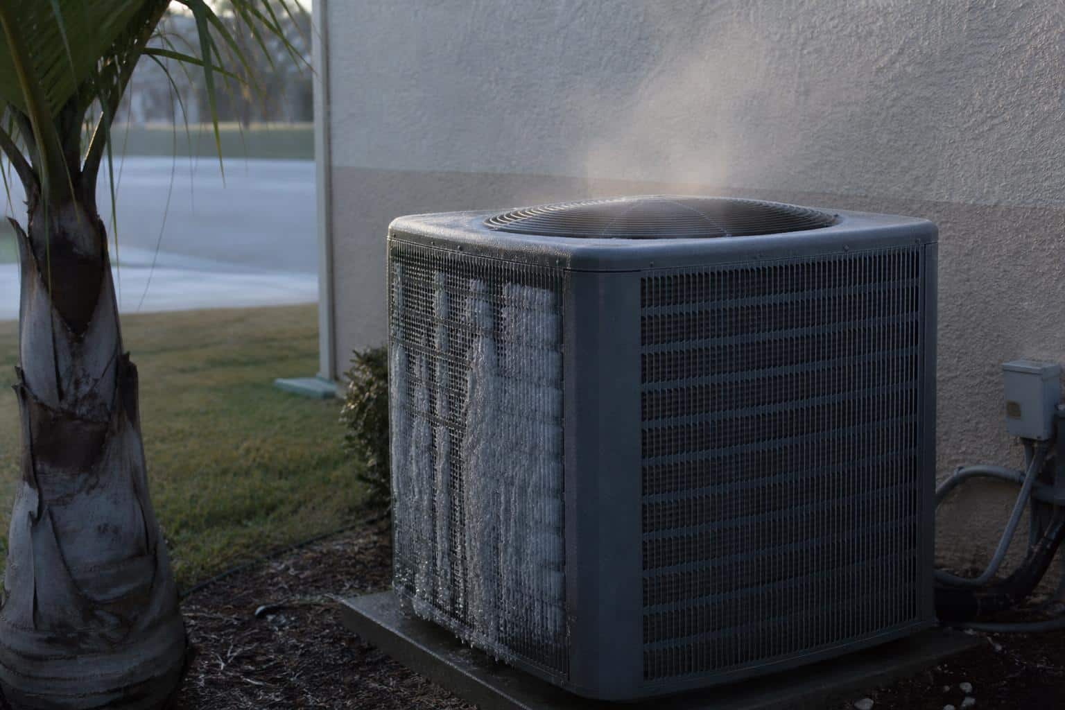 Brass four-way reversing valve with solenoid coil inside a residential heat pump condenser