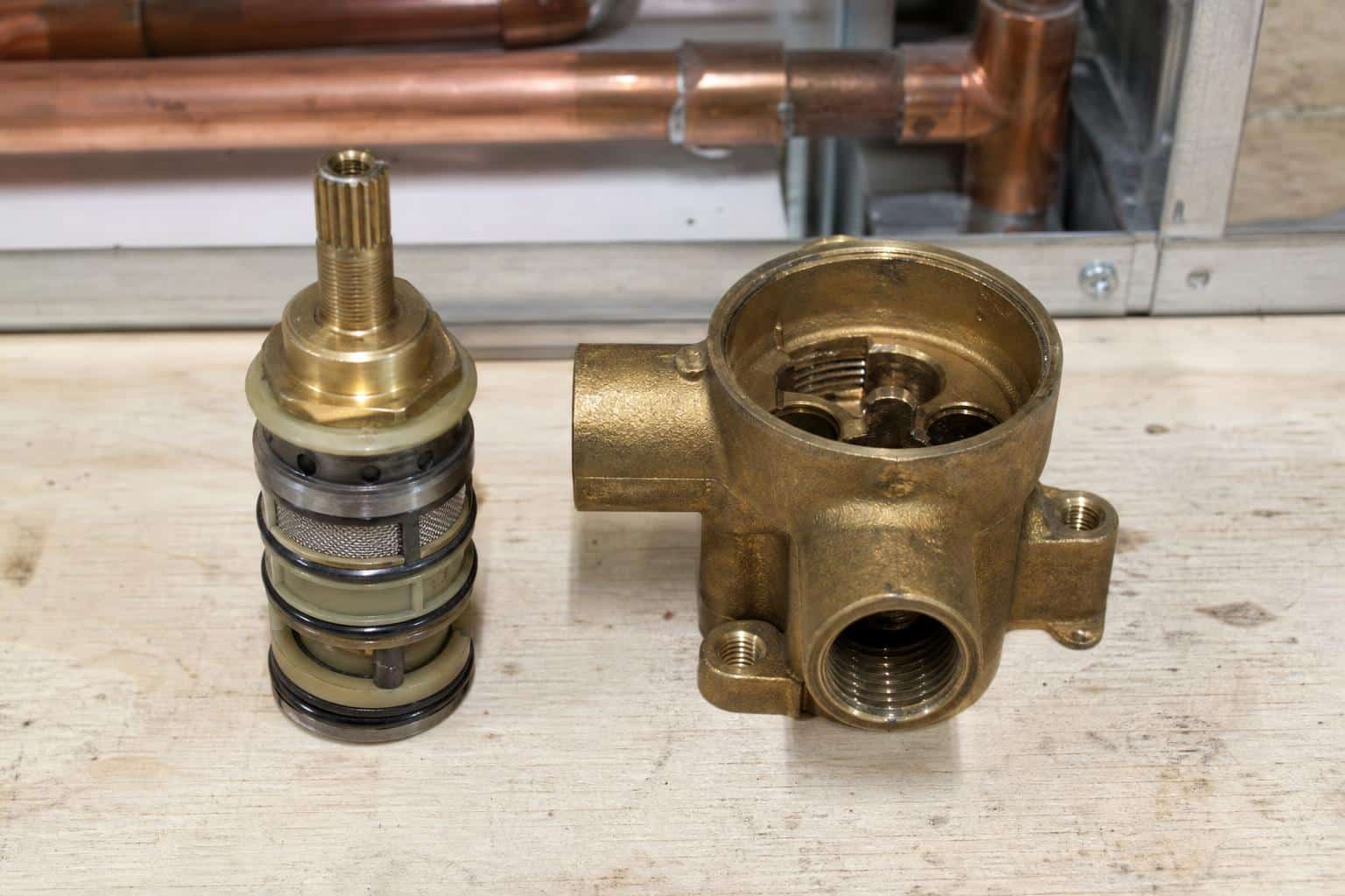Cross-section diagram of a pressure-balancing shower valve cartridge showing the spool mechanism
