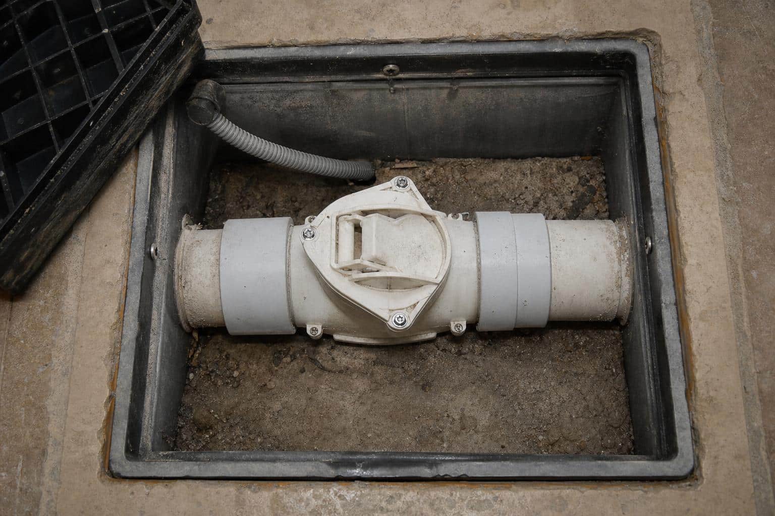 Cutaway diagram of a sewer backwater valve installed in a residential lateral pipe
