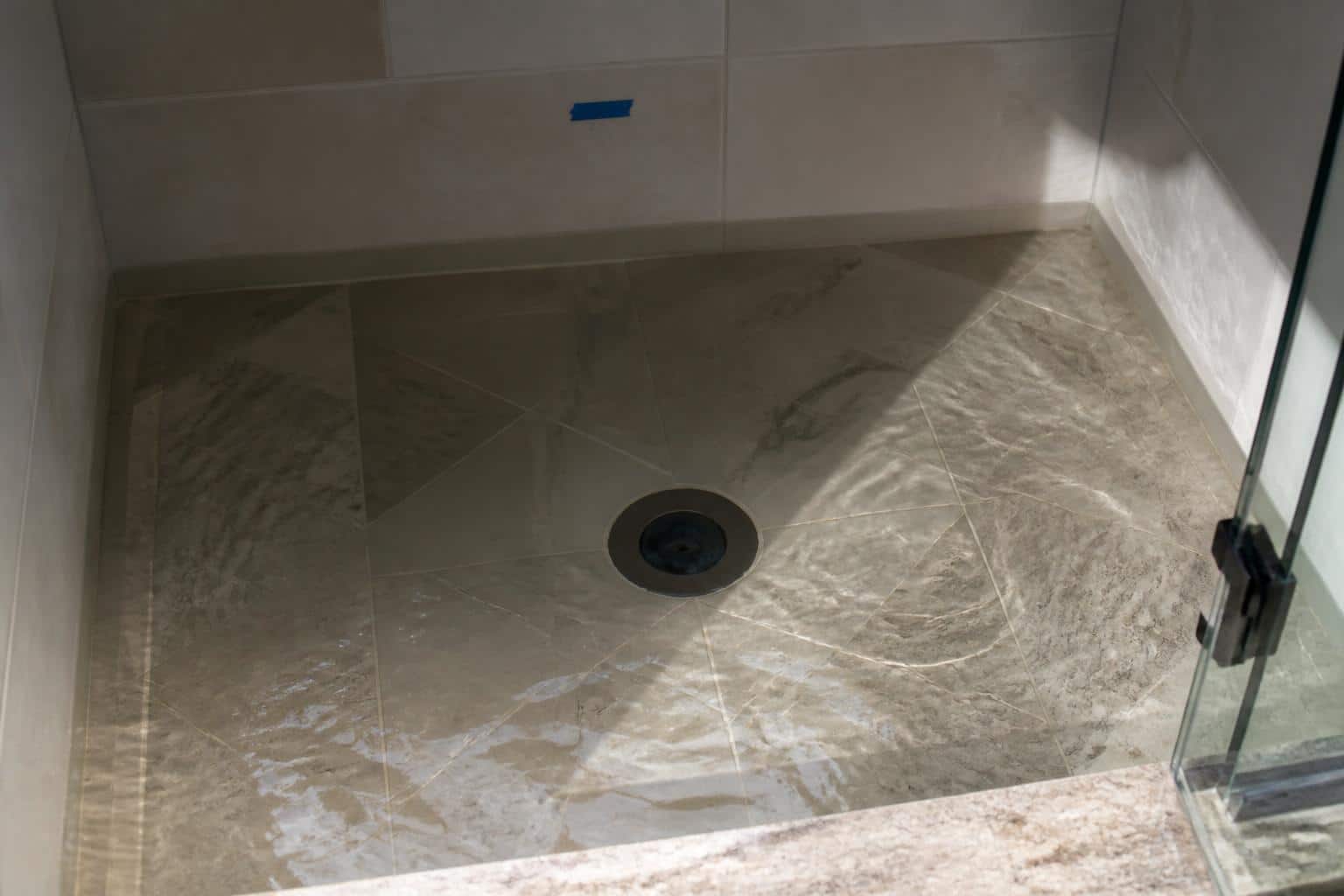 Tiled walk-in shower floor with center drain in a Florida bathroom