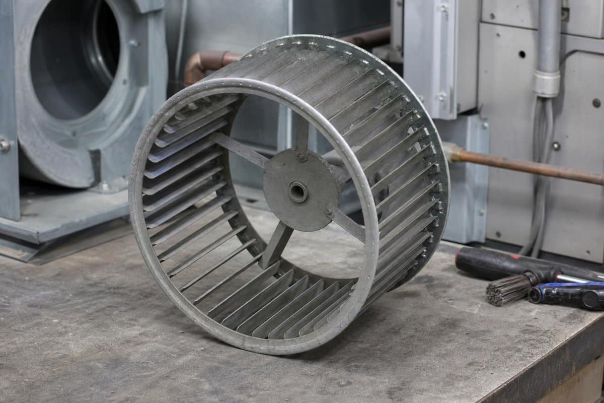 Metal blower wheel on an HVAC workbench