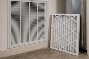 Pleated air filter beside a return grille