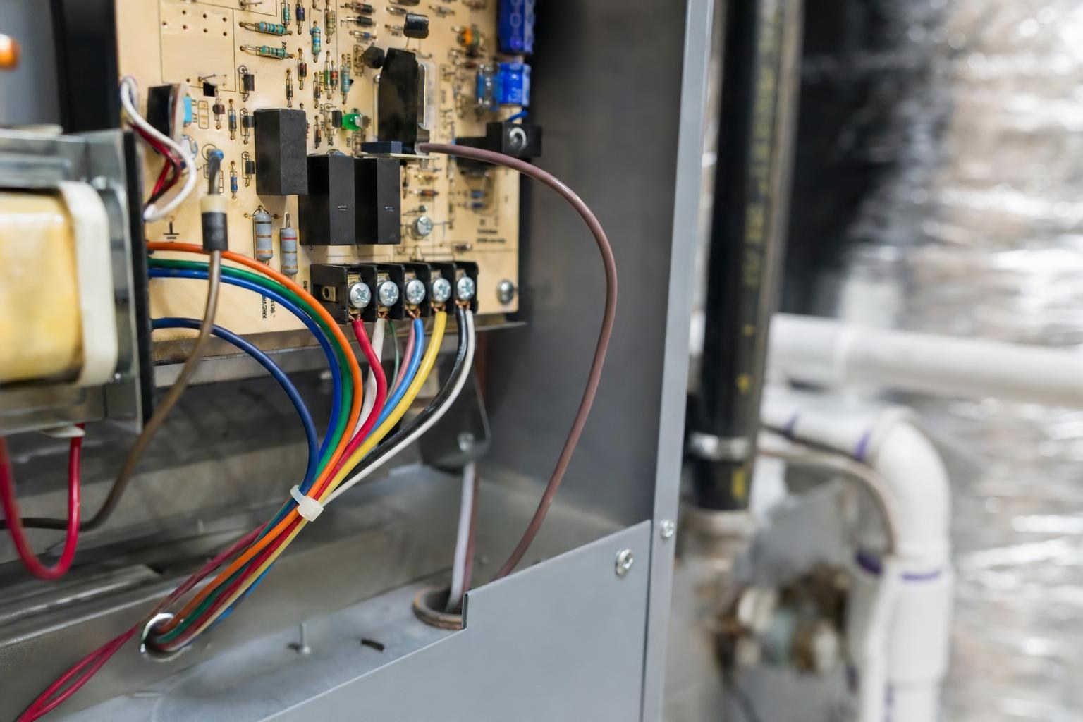Low-voltage thermostat wiring terminals on an air handler control board showing labeled C, R, Y, G, and W terminals